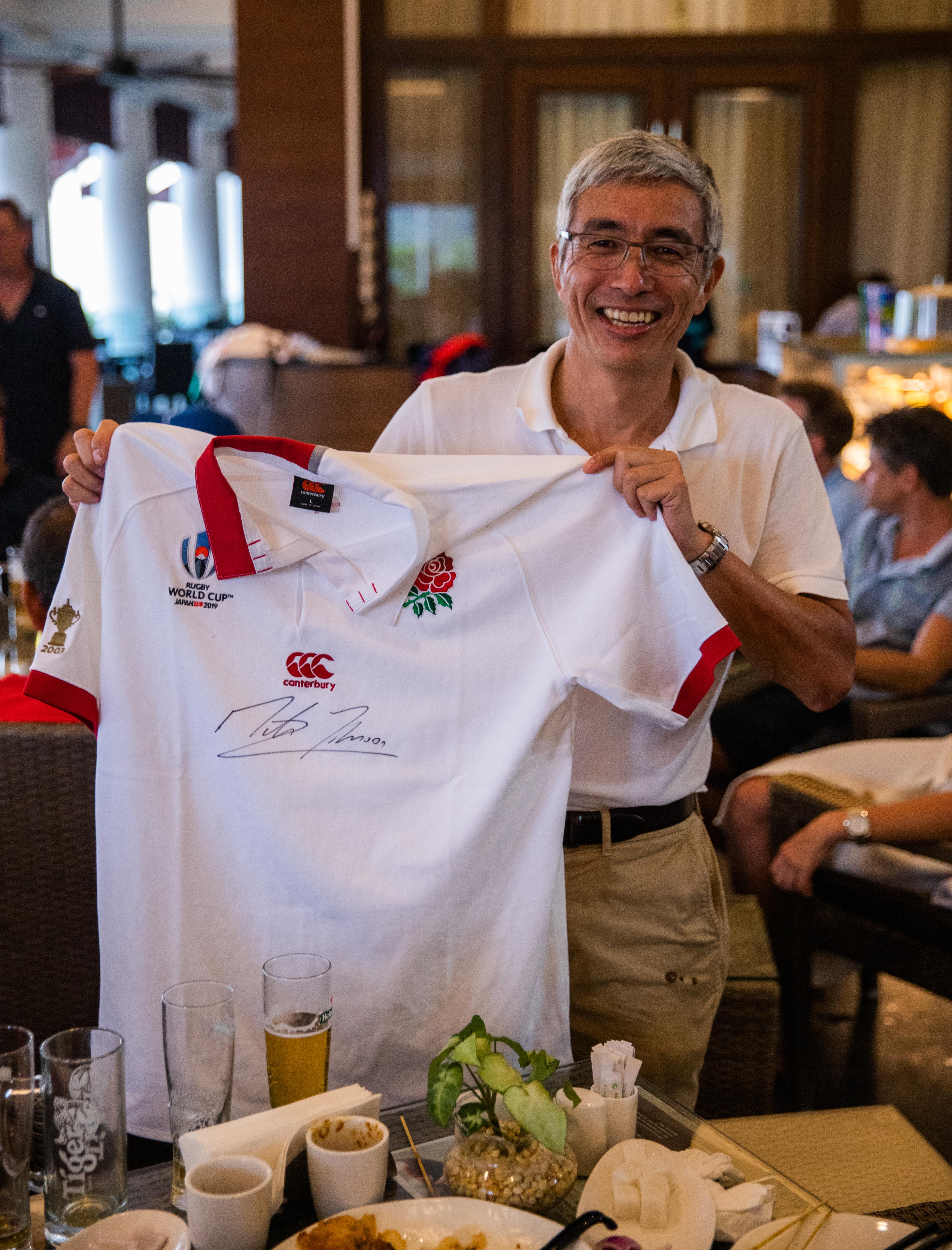 man showing signed rugby shirt