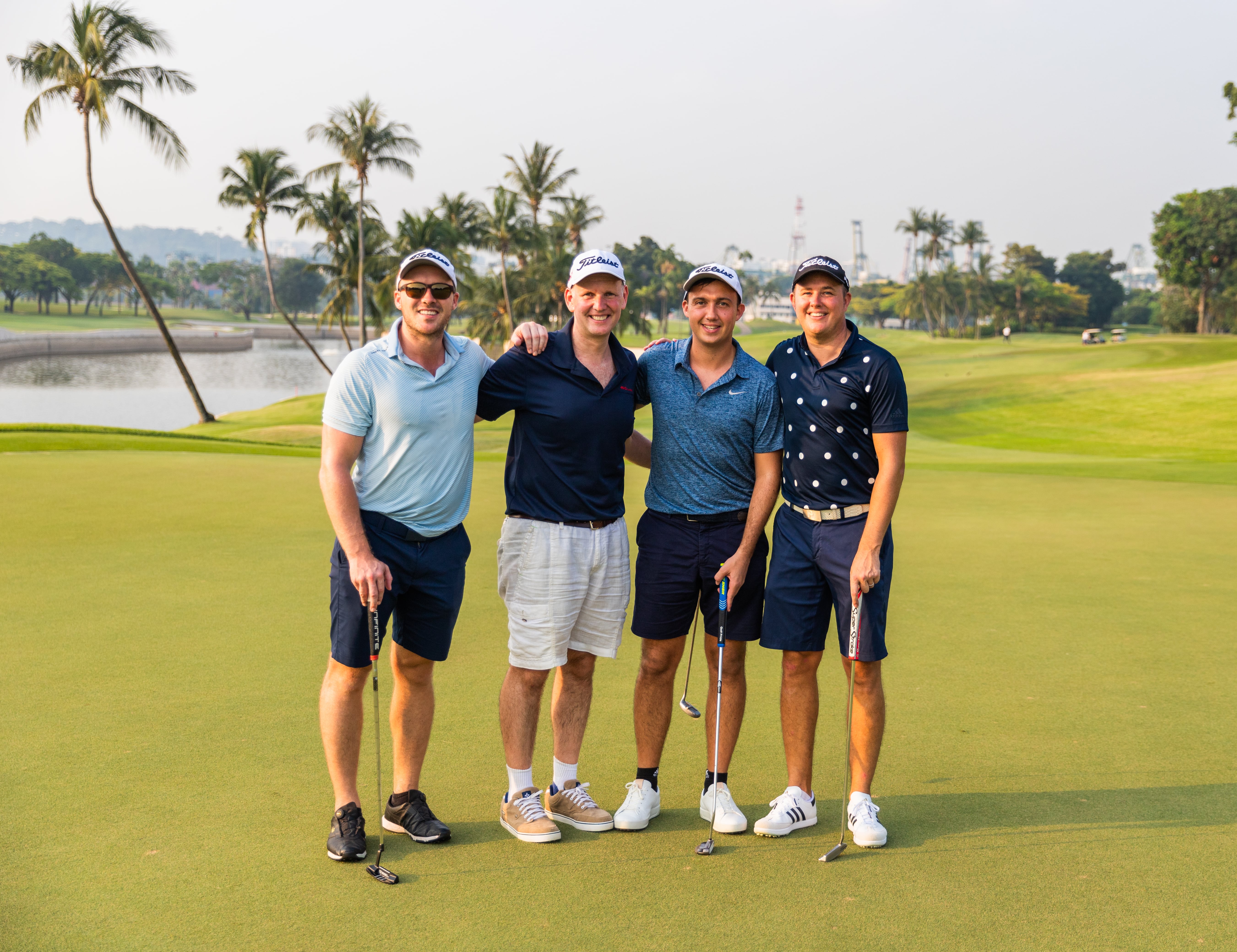 4 golfers smiling at camera