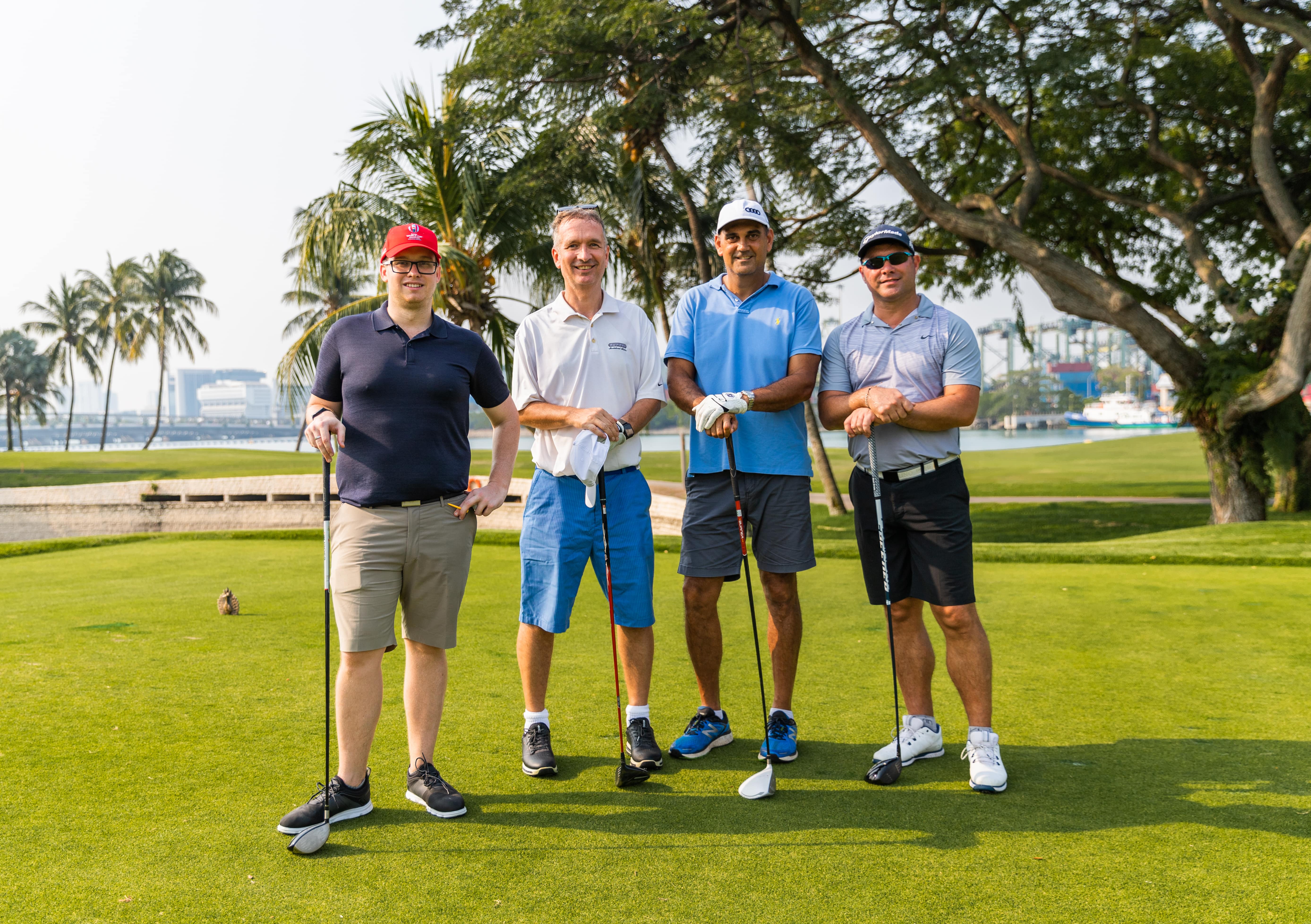 4 golfers smiling at camera