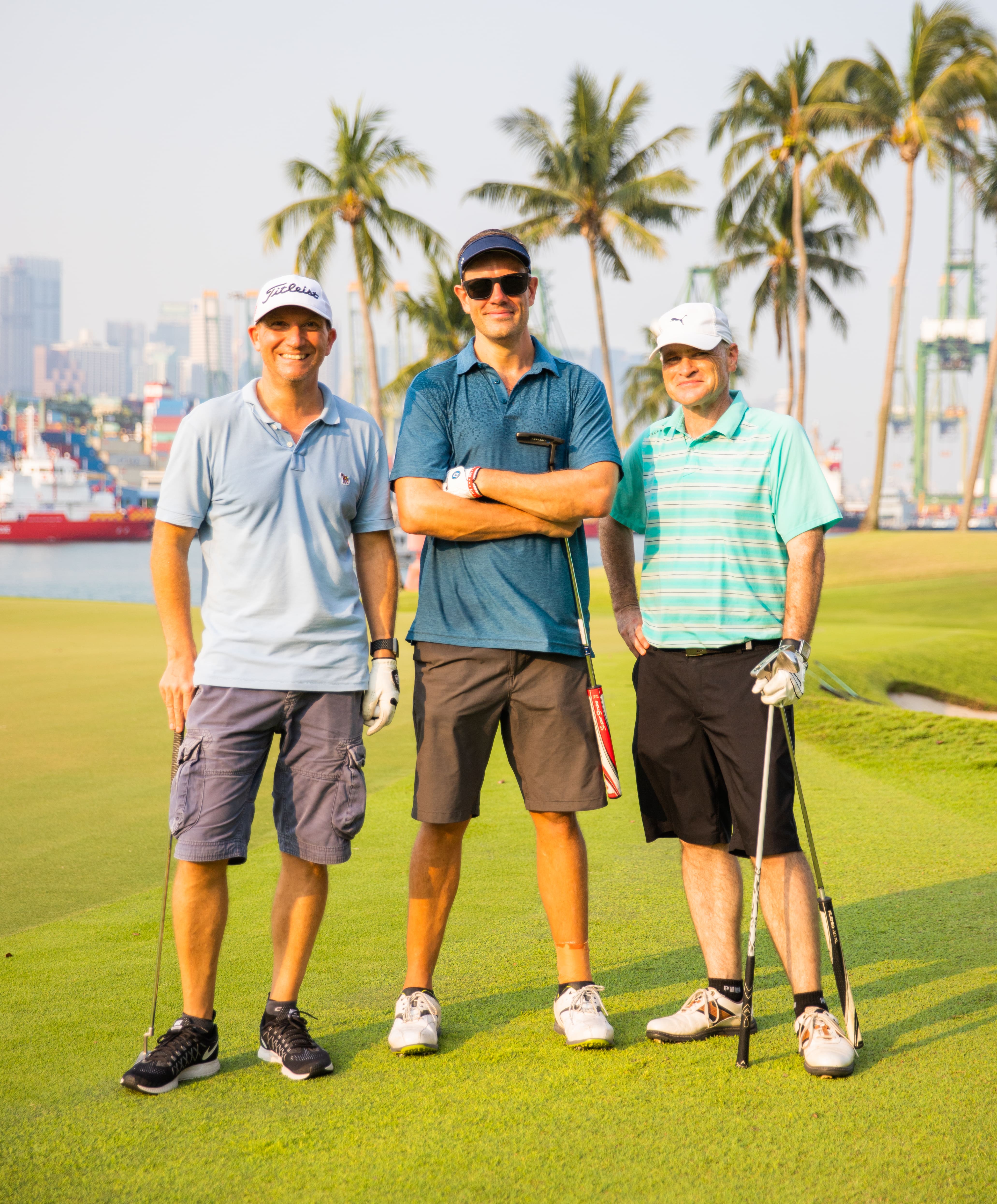 3 golfers smiling at camera